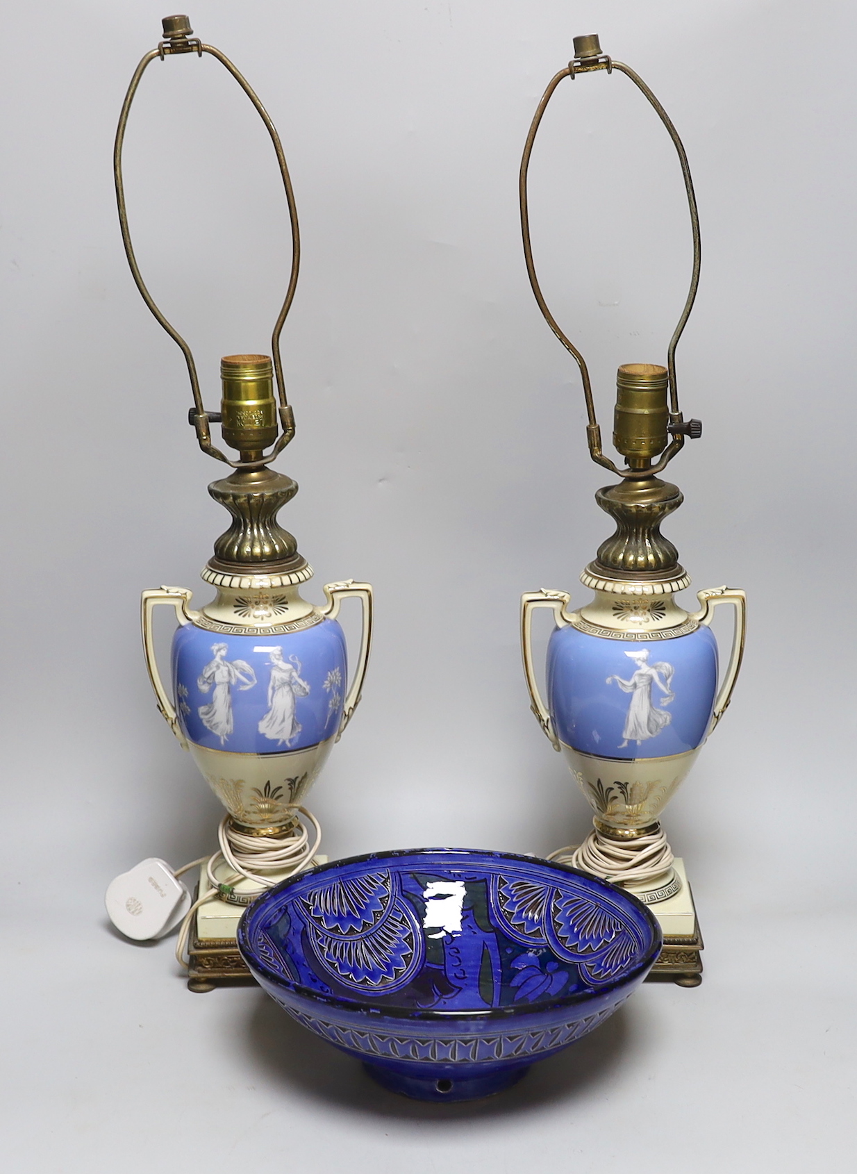 A pair of urn shaped lamps decorated with classical ladies and Greek key borders, together with a pottery bowl, largest 61cm high overall